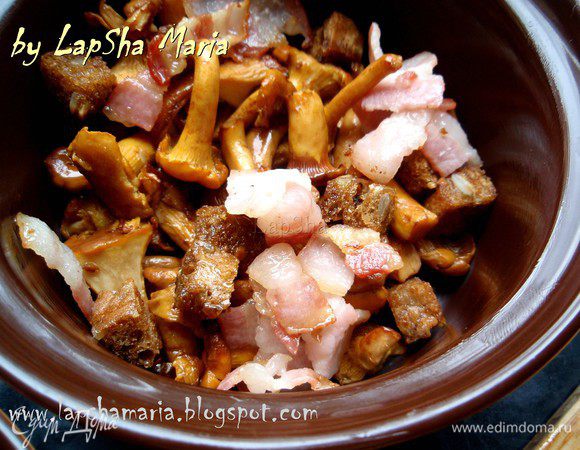 В два горшочка или кокотницы поровну распределяем лисички, бекон и гренки.