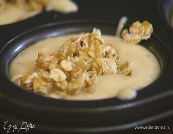 Половником разлить тесто по формочкам для маффинов, заполняя их на 2/3 объема, сверху на каждый маффин выложить по 1 ст. ложке хлопьев с медом.