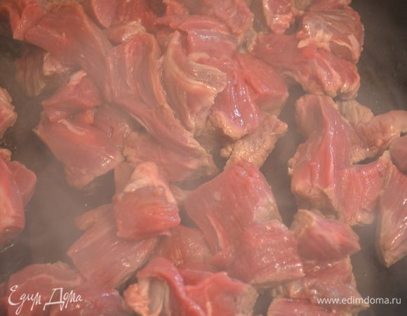 Разогреть в большой сковороде масло и обжарить на нем мясо со всех сторон. 