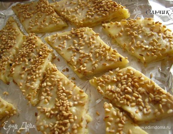 Переносим тесто на фольгу или бумагу для выпечки. Разрезаем на ромбики. Смазываем молоком при помощи кисточки. Присыпаем оставшимся кунжутом. Выпекаем минут 15 при 190 в заранее разогретой духовке.