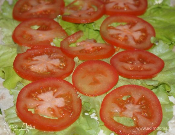 На листья салата выложите помидоры, нарезанные тонкими кружочками.
