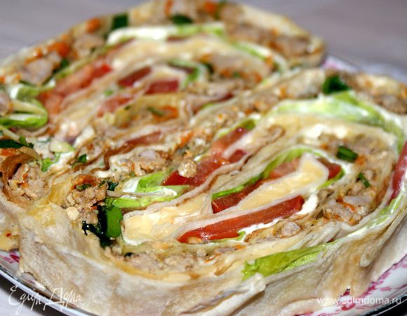 Сверните лаваш рулетом, заверните в пищевую пленку и отправьте в холодильник как минимум на 30 минут. Достаньте из холодильника, снимите пленку и нарежьте порционными кусочками. Приятного аппетита!