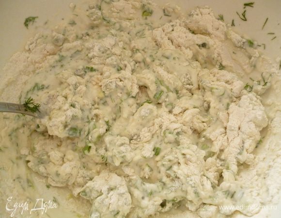 Выливаем кефир в миску,добавляем соду,перемешиваем ложкой и даем постоять 5 минут. Добавляем соль,мелко нарезанную зелень. Затем понемногу вмешиваем муку.