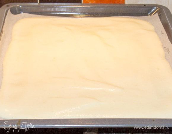 Взбить белок до пиков. Отдельно взбить желток с 2 ст.л. сахарной пудры и 2 ст.л. горячего воды до светлой пышной пены. Осторожно смешать белок и желтковую пену. Добавить крахмал, ваниль и соду и еще раз аккуратно перемешать.Нужно обмерить нашу форму, для того, чтоб определить размер коржа. Учитывать надо и то, что дно тоже закрывается бисквитом. Противень застелить пергаментом и выложить тесто, размазав его ложкой в слой около 5 мм чуть больше, чем нам нужно для формы, для того, чтоб потом вырезать ровный бисквит. 