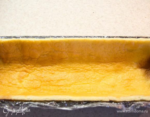 Теперь формируем наше полено. Для этого форму нужно застелить пищевой пленкой, чтоб потом без труда вытащить полено из формы. Поливаем наш корж сиропом, чтоб он стал мягким и податливым для работы. Вырезаем из коржа прямоугольник равный размеру формы без дна и укладываем его в форму. Из оставшейся части вырезаем прямоугольник равный дну полена. Обрезки оставляем они пойдут в средний слой.