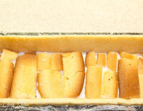 Выливаем половину крема. Выкладываем поверх обрезки коржа.