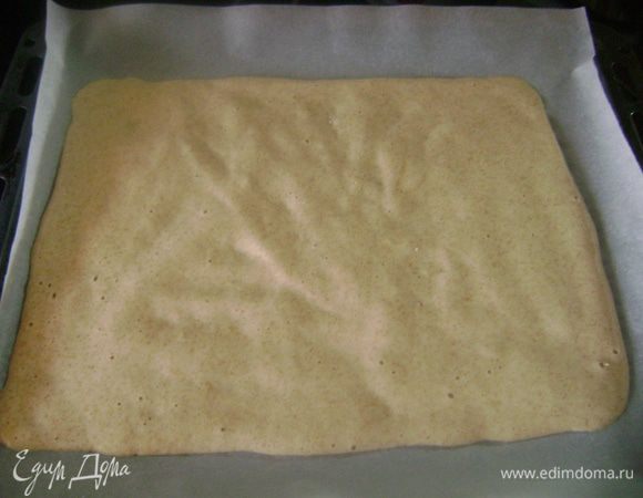 На противень, выложенный пергаментной бумагой, вылить бисквитную массу и аккуратно разровнять до прямоугольника.