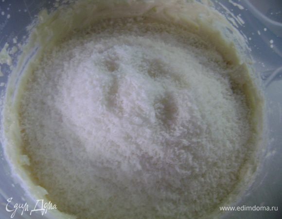 Затем продолжая взбивать на средней скорости, по столовой ложке влить остывший желатин. Далее всыпать кокосовую стружку и перемешать.