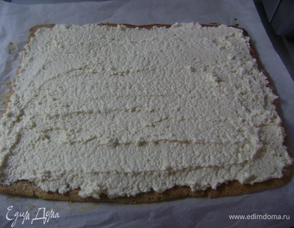 Аккуратно снять бисквит с пергаментной бумаги (если рвется, помочь ножом). Выложить крем по всей поверхности... 