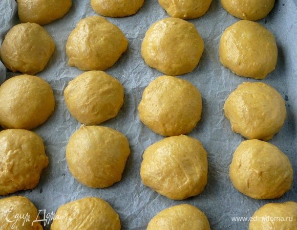 Через час тесто должно увеличиться в 2 раза. Разделить его на небольшие шарики и сформировать булки. Выложить на противень на лист бумаги для выпечки.