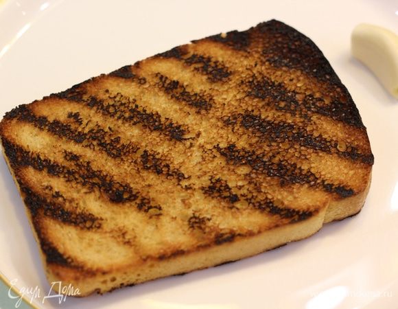 Теперь необходимо поджарить хлеб. Нарежьте его довольно тонко - около сантиметра толщиной. Обжарьте хлеб либо на сковороде гриль, либо на гриле. В крайнем случае можно воспользоваться тостером (вкус будет несколько слабее).