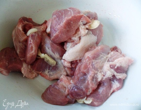 Мясо вымыть, нарезать на средние кусочки и нашпиговать чесноком