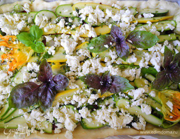 Затем раскидываем сверху кружочки свежего помидора. Кабачки искупаем в базиликово-чесночном соусе и разложим на помидоры. Сверху покрошим брынзу(фету) и украсим базиликом. 