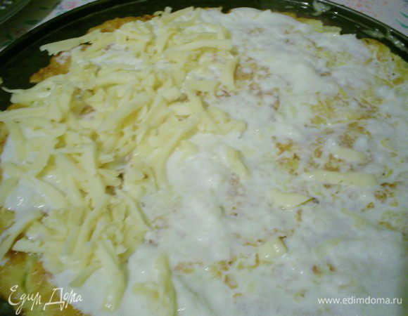 Собирать торт нужно сразу, пока блинчики горячие, чтобы сыр расплавился. На блюдо выкладываем первый готовый блинчик. Смазываем его небольшим количеством соуса и посыпаем тертым сыром.
На верх выкладываем следующий блинчик прямо со сковороды и хорошенько прижимаем лопаткой и т.д.