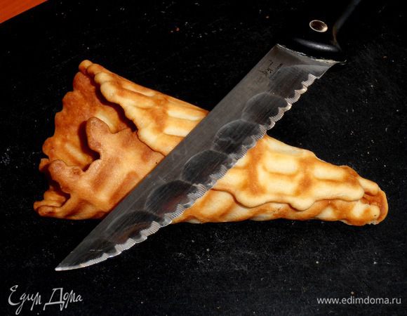 Но если заранее купить мороженое в коробке,то сейчас приготовим вафельные рожки для него! На вафельницу теперь наливаем 1 ст.л.теста,а готовый круг сворачиваем конусом и прижимаем ножом к доске.