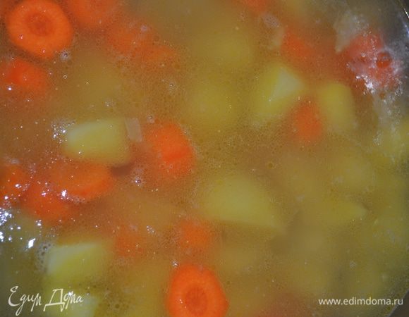 Картофель и морковь очистить, нарезать кубиками, добавить к луку. Всё залить бульоном и варить на маленьком огне до полного приготовления картофеля. 
P.S. Я готовлю бульон сама. Нарезаю мясо красивыми кубиками и варю со специями пару часов. После мясо можно использовать для украшения супа. И красиво и вкусно.