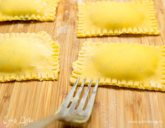 Пройдитесь пальцами со всех сторон начинки, чтобы удалить излишки воздуха, и разрежьте на отдельные равиоли. Края можно украсить с помощью вилки.