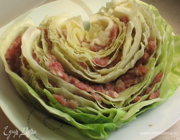 Собираем кочанчики: Отжать воду, положить каждую половинку кочана в глубокую тарелку для супа, чтобы не развалились. Фарш разделить на 4 части и начать укладывать его между листьями капусты (сначала с одной стороны, затем с другой)...аккуратно тонкими слоями...вилочкой