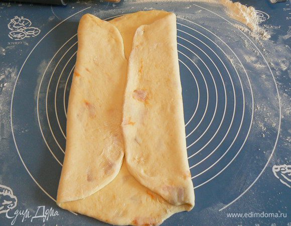 Затем тесто переложить на стол посыпанный мукой, обмять, раскатать прямоугольный пласт, смазать растительным маслом , затем завернуть на верх до середины одну часть теста,