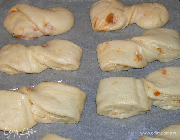 Булочки уложить на противень застеленным пергаментом, смазанным растительным маслом, накрыть пленкой и убрать в теплое место на 20 минут.