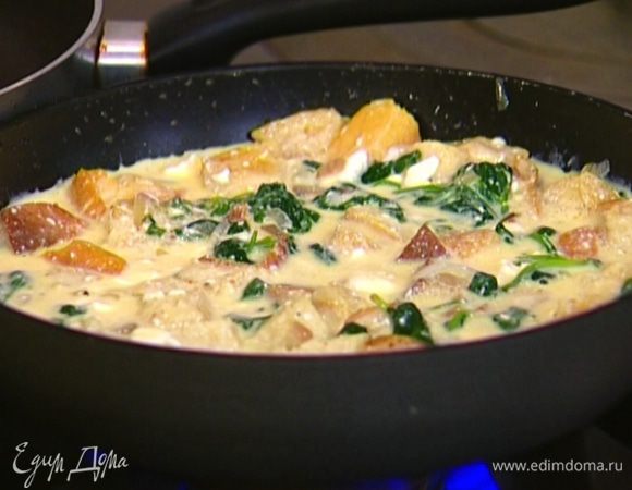 Разогреть сковороду, где жарились лук и шпинат (масло не добавлять), вылить яичную массу, присыпать измельченным руками базиликом, накрыть крышкой и жарить 5 минут.