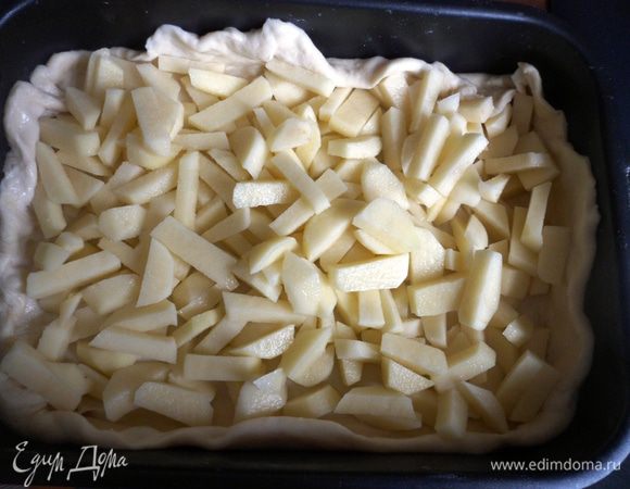 Помойте, очистите и нарежьте небольшими брусочками картофель. Раскатайте часть теста и уложите его на противень, смазанный растительным маслом. Сделайте небольшие бортики. Выложите нарезанный картофель, посолите. 