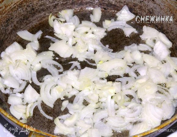 Лук разрезаем на четыре части, тонко нарезаем. На сковороде разогреваем немного масла, отправляем лук. Держим несколько минут до прозрачности.