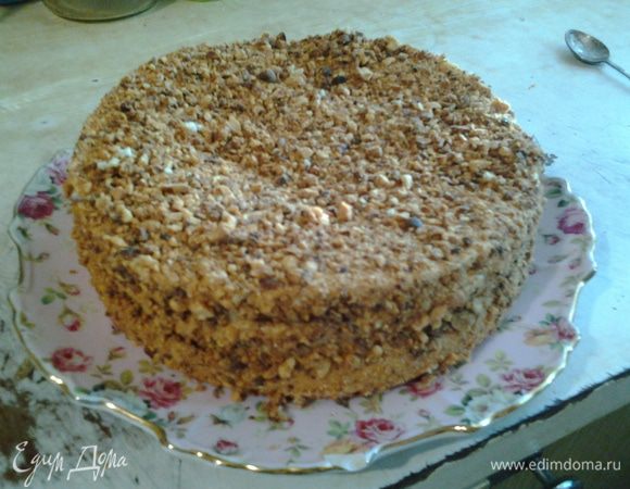 Бисквит разрезать на 2 (у меня 3) части. нижний корж пропитать сиропом и намазать кремом. То же проделать и с верхним коржом. оставшимся кремом обмазать верх и бока торта. Посыпать со всех сторон измельченным арахисом