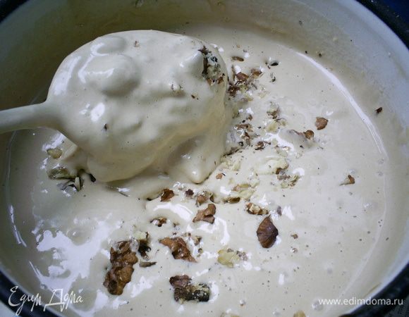 Добавляем муку, гашенную уксусом соду и рубленые орехи. Тщательно перемешиваем ложкой.
