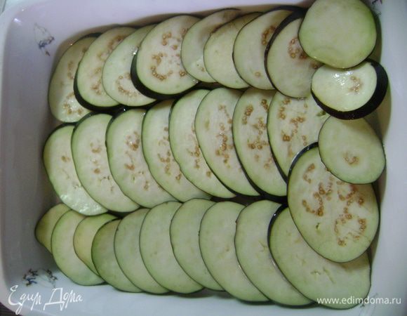 Дольки баклажанов помыть, уложить на противень внахлест, сбрызнуть маслом и запекать в духовке 5 мин. 