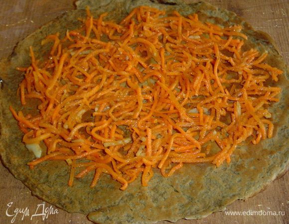 На блинчики выкладываем морковь по-корейски и распределяем по всей поверхности,
