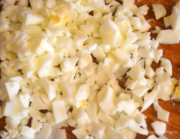 Из вареных яиц аккуратно вытащить желток, а белок мелко изрубить и также добавить в фарш. 