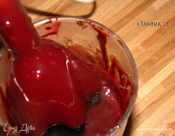Снимем кастрюлю с огня. Помешивая, вливаем подкрашенный сахарный сироп. Взбиваем венчиком, пока смесь не станет однородной.
Переливаем смесь в высокую посуду. 
Глазурь удобнее перемешивать с помощью погружного блендера, чтобы смесь была однородной и без пузырьков. Глазурь должна быть гладкой, тогда она равномерно покроет изделие. Остудим до комнатной температуры.
