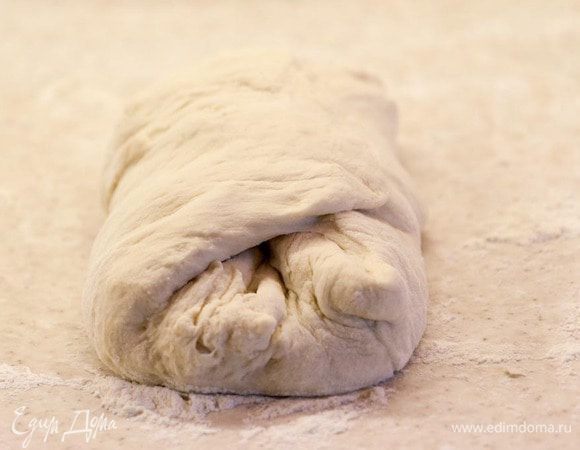 Формируем наш хлеб. Из предложенного кол-ва ингредиентов получается 2 буханки. Делим тесто пополам. Одну половину растягиваем руками в небольшой прямоугольник, складываем стороны друг к дружке и приминаем тесто.