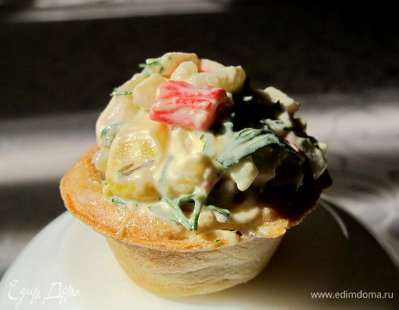 Тарталетки с крабами. Крабовые палочки и яйцо мелко порезать, добавить рис, консервированную кукурузу, мелко порезанный укроп. Заправить майонезом.