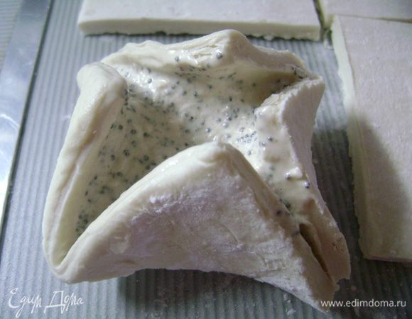 В центр каждого квадрата разложить начинку и края загнуть к середине, формируя гнездышко.