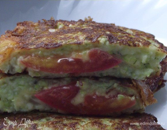 Затем на сковороду налила растительное масла и начала жарить оладки.Сначала ложкой насыпала тесто,немного растягивала его ,что бы получилась тонкая лепешка.На лепешку клала кружок помидора,на помидор пластинку сыра и все это накрывала еще кабачковым тестом.Помидор и сыр получается по середине.Жарила с обоих сторон на медленном огне.Увы фото готовки   не получились.
И вот такие оладки  вышли.Очень нежные,тающие во рту.