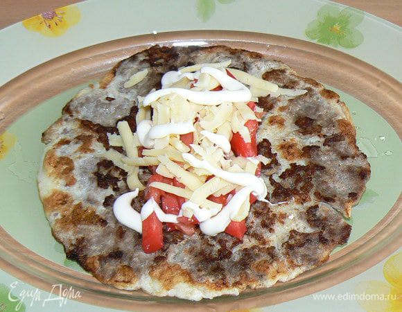 Выложите бризоль на блюдо яйцом вниз. Посыпьте тертым сыром, помидоры нарежьте кусочками. Смажьте майонезом.