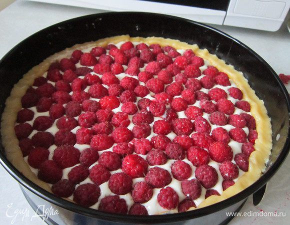 Выложите на тесто творожную начинку, сверху — малину. Аккуратно прижмите бортики до уровня начинки.
