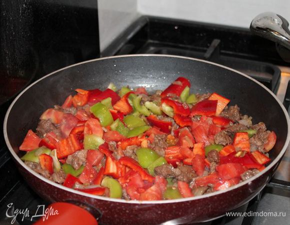 в это время,нарезаем перцы и помидор кубиками,и добавляем к обжареному мясу