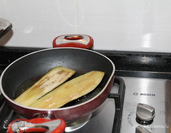 теперь очистим полностью баклажаны от кожуры, нарежем вертикально, шириной 0,5 мм, посолим и подождем,в это время разогреваем масло для обжарки (когда я готовила, то не очищала полностью баклажаны и при запекании, кожура немного жестковатая получилась, так что лучше полностью очищать)
обжариваем наши баклажаны до коричевого цвета с обоих сторон и выкладываем на бумажное полотенце, чтоб остатки масла стекли