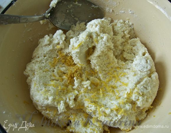 Творог растереть с сахаром, добавить яйцо, муку, манную крупу. Потереть на мелкой терке цедру лимона. Тщательно все перемешать.