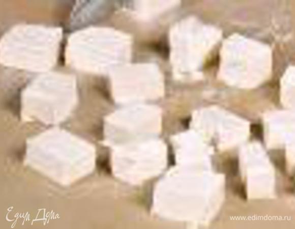 Фету нарезать кубиками. Смешать овощи и маслины, полить заправкой. Разложить сверху фету и подать к столу.