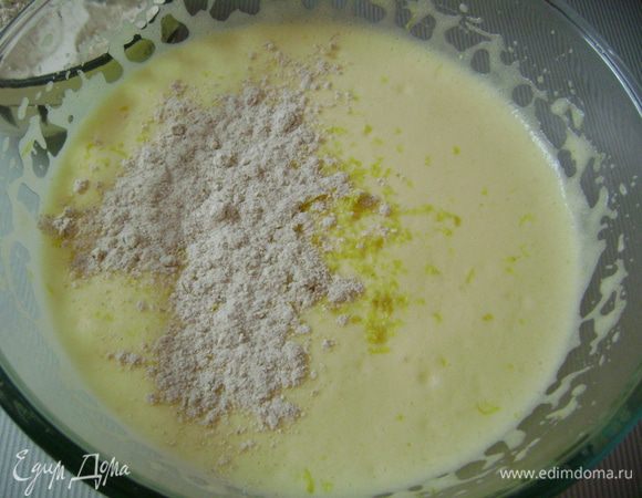 Всыпать лимонную цедру и аккуратно по ложечке добавлять просеянную муку, тщательно размешивая.