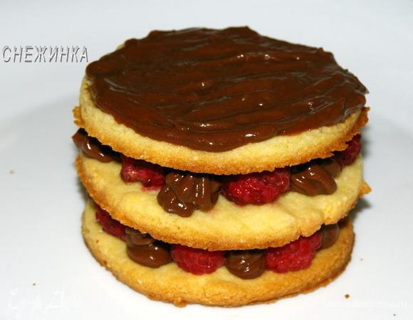 Повторяем второй ряд, поставив коржики с кремом и малиной один на один. Третий верхний коржик смазываем кремом.