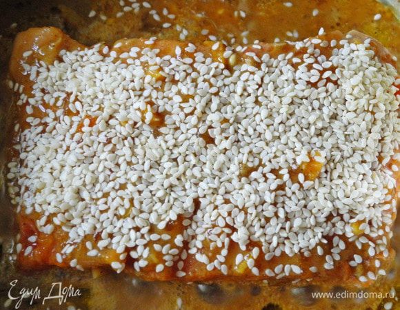 Потом есть два варианта приготовления: мой и Ники Белоцерковской.
По моему варианту лосось жарится на толстостенной сковородке.  Немного разогреть сковороду, налить  оливковое масло, положить рыбу кожей вниз, залить соусом, посыпать кунжутными семечками, накрыть сковороду крышкой и готовить примерно 10-15 минут (10 минут  для кусочков по 250 г и 15 - для куска 500 г) на умеренном огне. Соус весь добавлять не надо, достаточно половины, чтобы он плотно закрывал дно, но не заливал рыбу полностью, количество зависит от диаметра вашей сковороды.