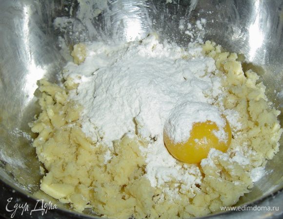 к полученной крошке добавляем яичный желток, ванильный сахар, остаток муки и замешиваем тесто.