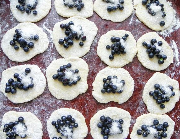 Раскатываем каждый кусочек теста в тонкую лепешку. Если вы любите большие вареники, то размером с ладонь, если любите поменьше, то и раскатывайте поменьше. Раскладываем чернику на каждый кусочек теста и посыпаем примерно по пол чайной ложки сахара.