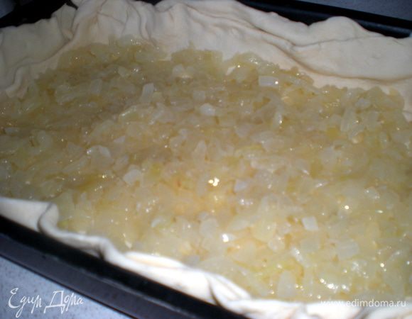 Тесто раскатать,противень смазать маслом и выстелить тестом, сделав бортики. На тесто выложить лук.