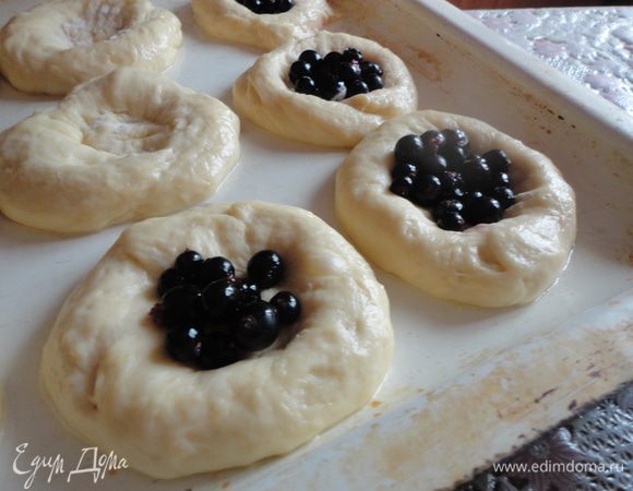 Смешать черную смородину с сахаром.
Продавить стаканом дырочку в ватрушке, выложить начинку.